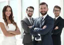 men and women smiling and posing in professional business attire