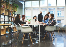 small group of young people dressed casually in an office meeting